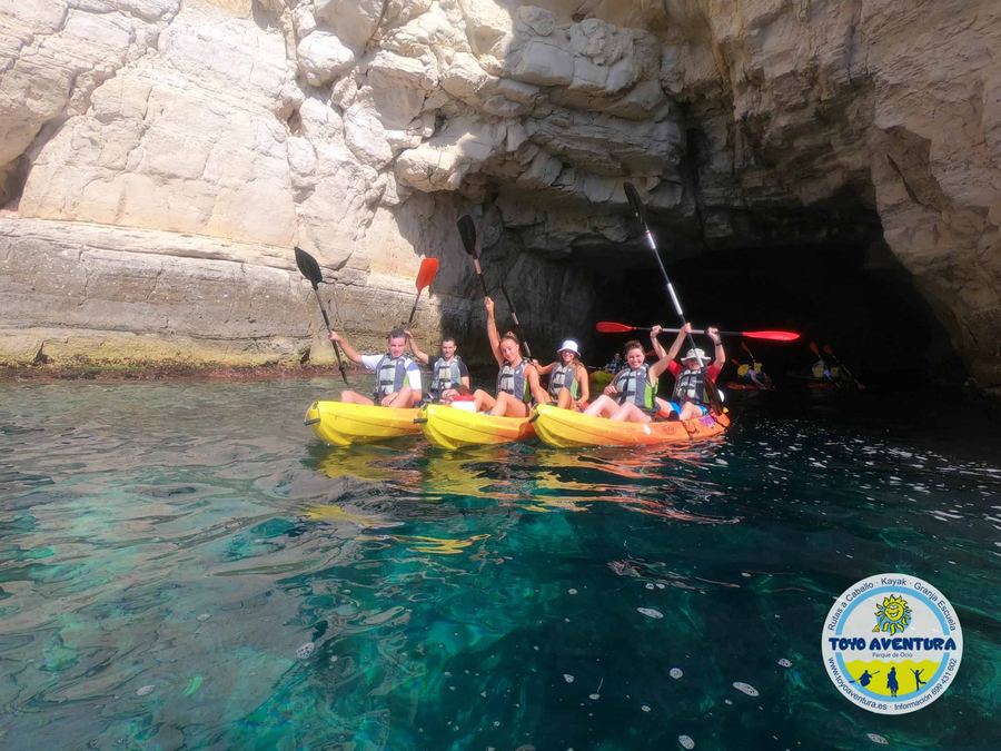 Grupo de kayakistas dentro de una cueva marina de Cabo de Gata sobre agua turquesa
